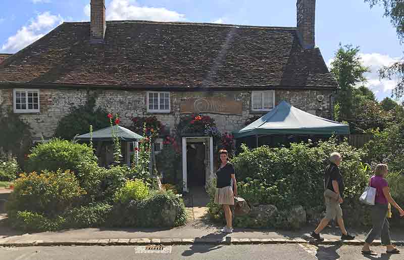 The beautiful stone exterior of the Henge Shop with shrubs.