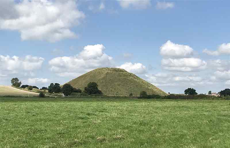 The monumental mound in the distance surrounded by fields.