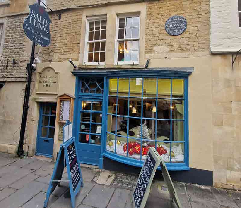 Front of the shop with blue painted bay windows and sign.